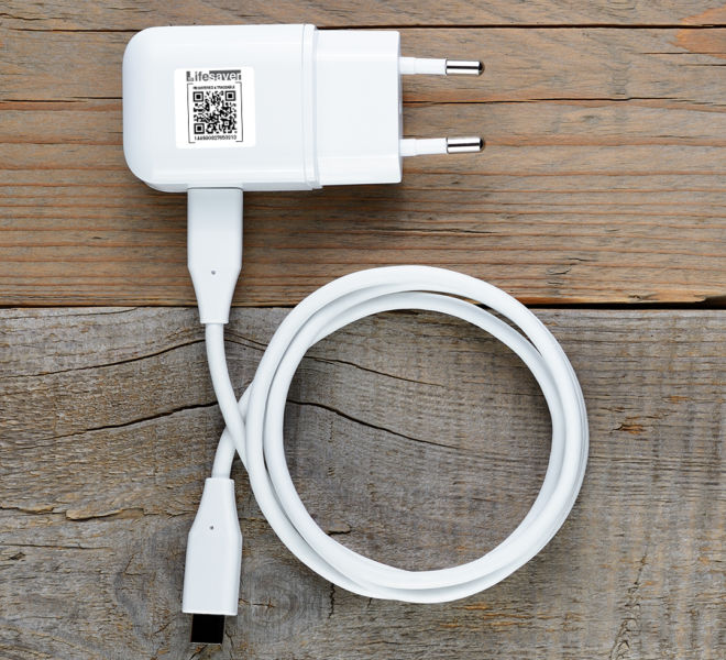 Charger for tablet or smartphone on wooden table top view