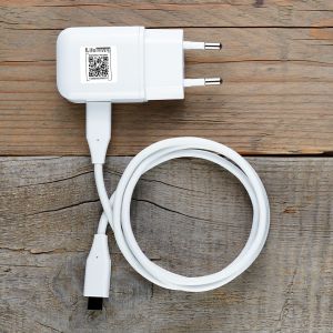 Charger for tablet or smartphone on wooden table top view