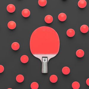 flat lay image of table tennis paddle and many balls central composition